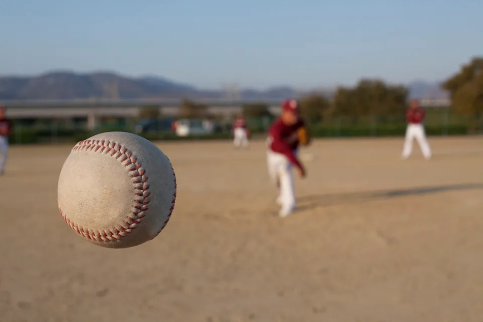 baseball in foreground, pitcher in distance